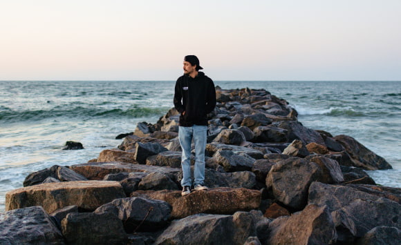 Expert in addiction treatment standing on rocks by the ocean